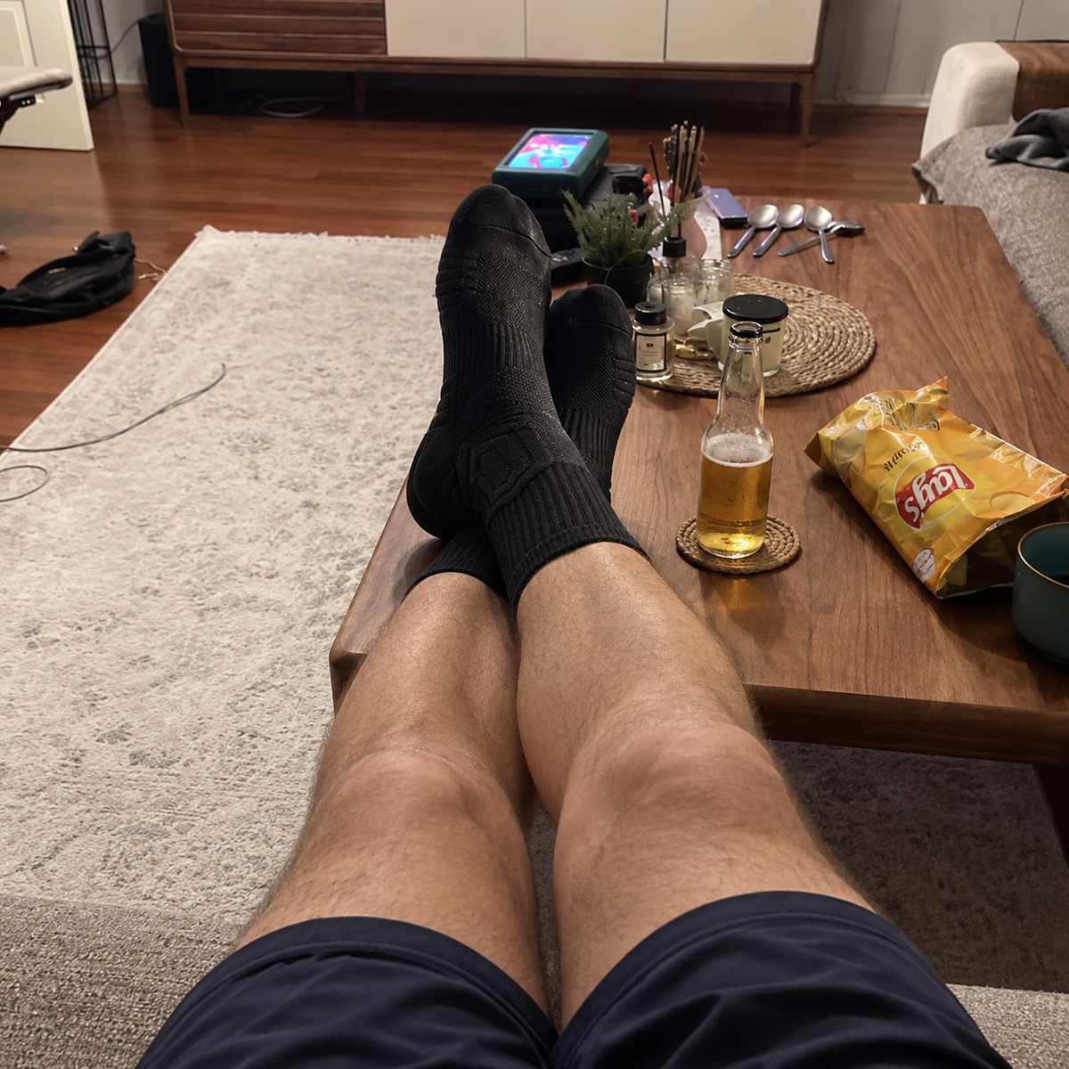 Jambes allongees sur la table basse apres le travail